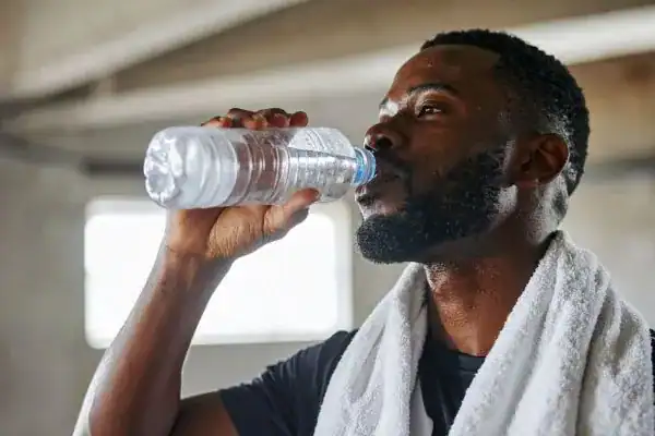 Image of man drinking water to improve hydration Ramsgate after work out.